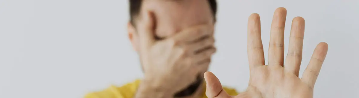 hombre tapándose la cara con la mano