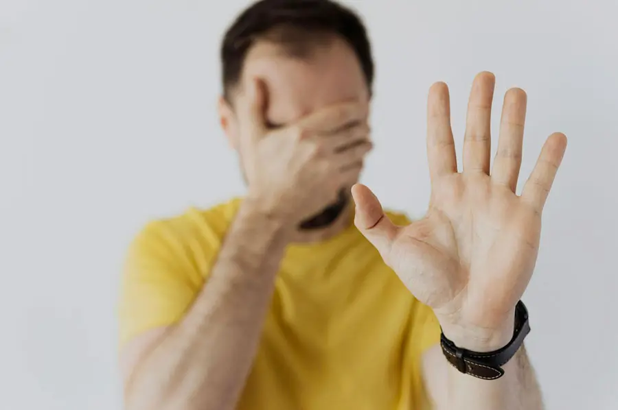 hombre tapándose la cara con la mano