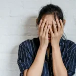 mujer tapándose la cara con las manos